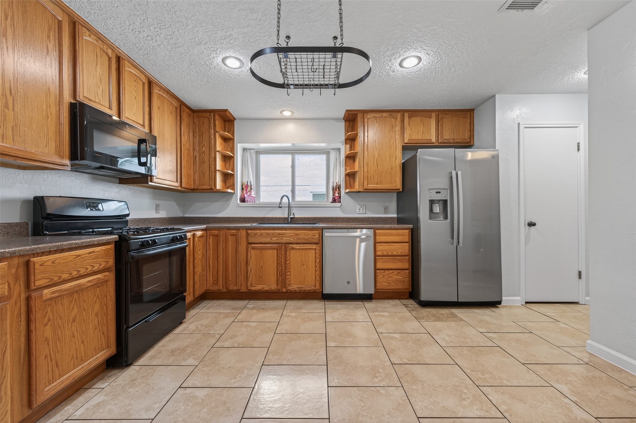 21315 Meadowhill Drive Spring, TX 77388 - Photo 9 of 31 a kitchen with stainless steel appliances granite countertop a stove a sink dishwasher a refrigerator and cabinets with wooden floor