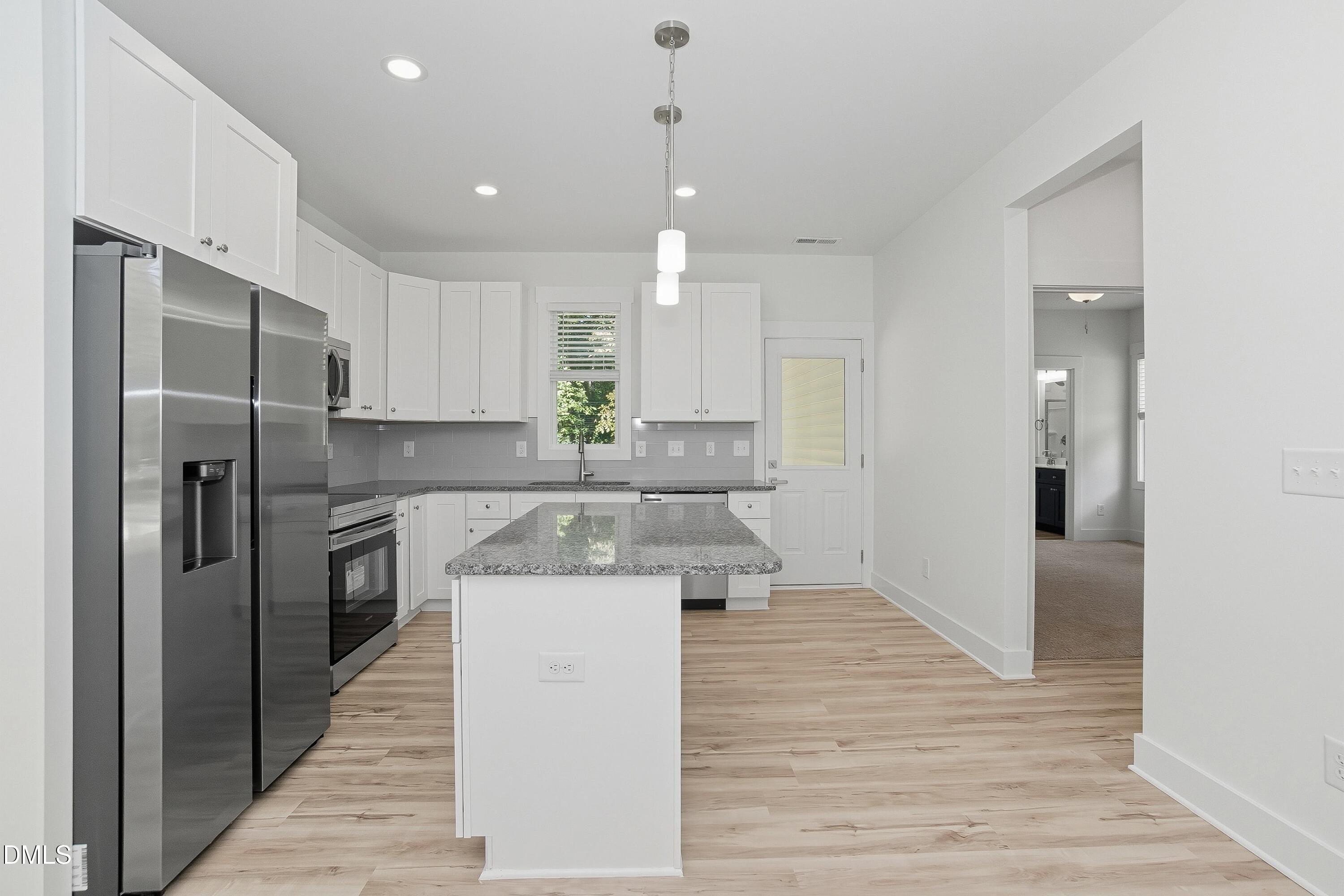 97 Gates Street Roxboro, NC 27573 - Photo 11 of 34 a kitchen with kitchen island white cabinets and stainless steel appliances