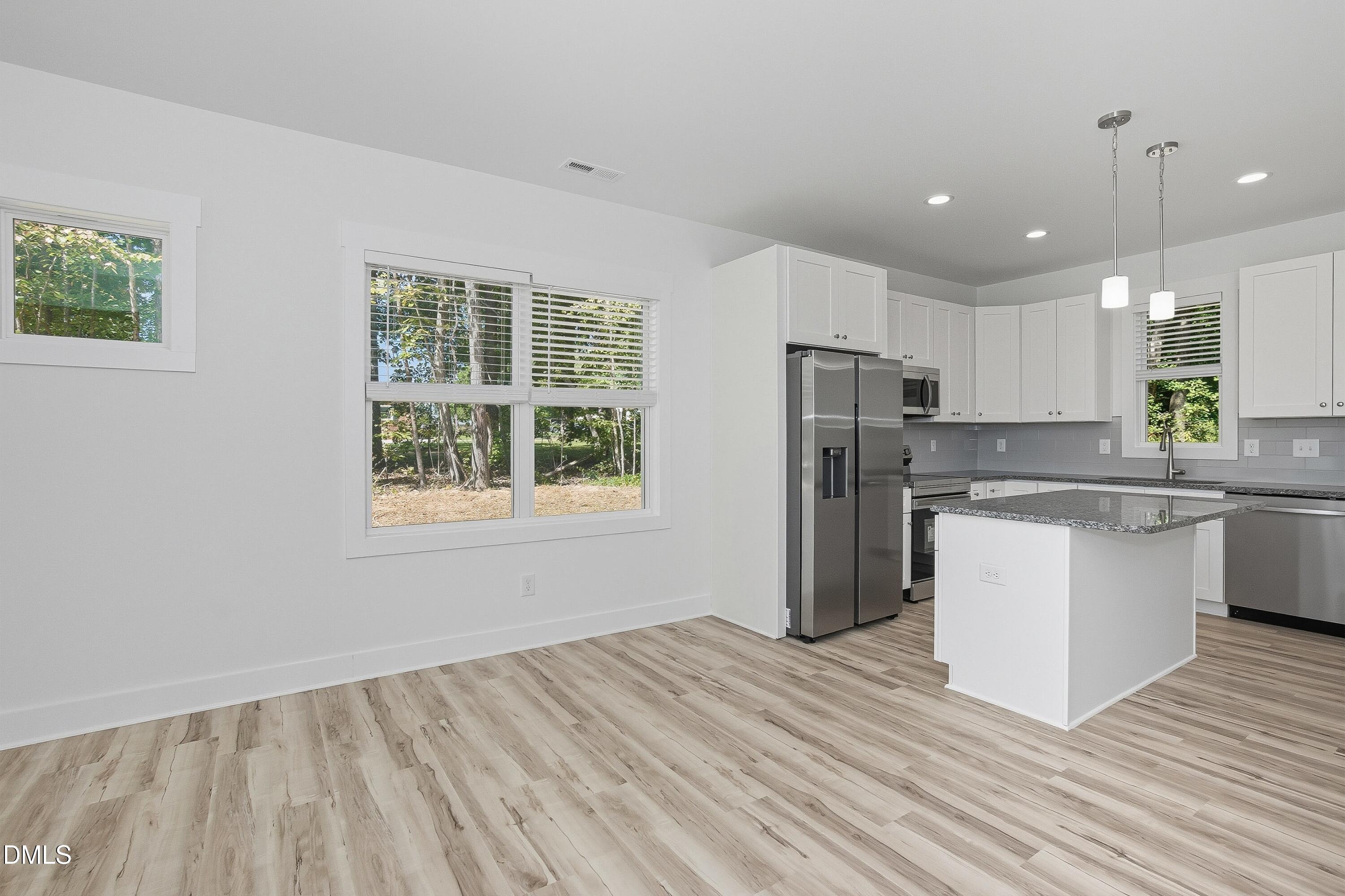97 Gates Street Roxboro, NC 27573 - Photo 12 of 34 a kitchen with refrigerator cabinets and wooden floor