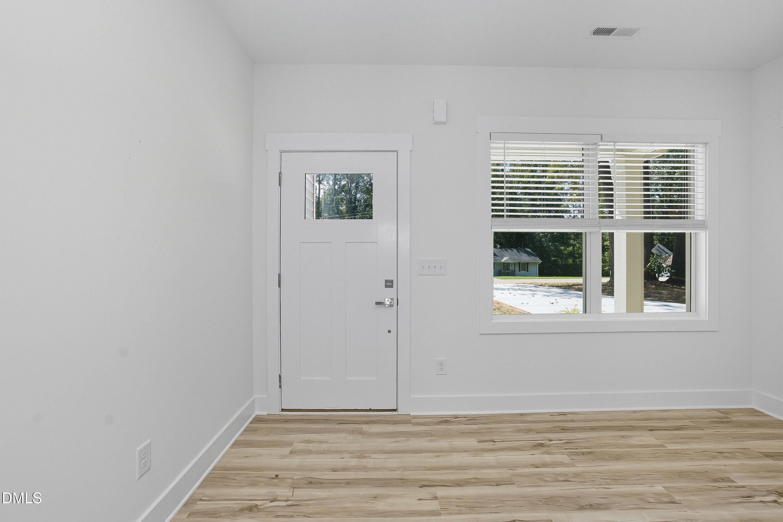 97 Gates Street Roxboro, NC 27573 - Photo 6 of 34 a view of an empty room with wooden floor and a window