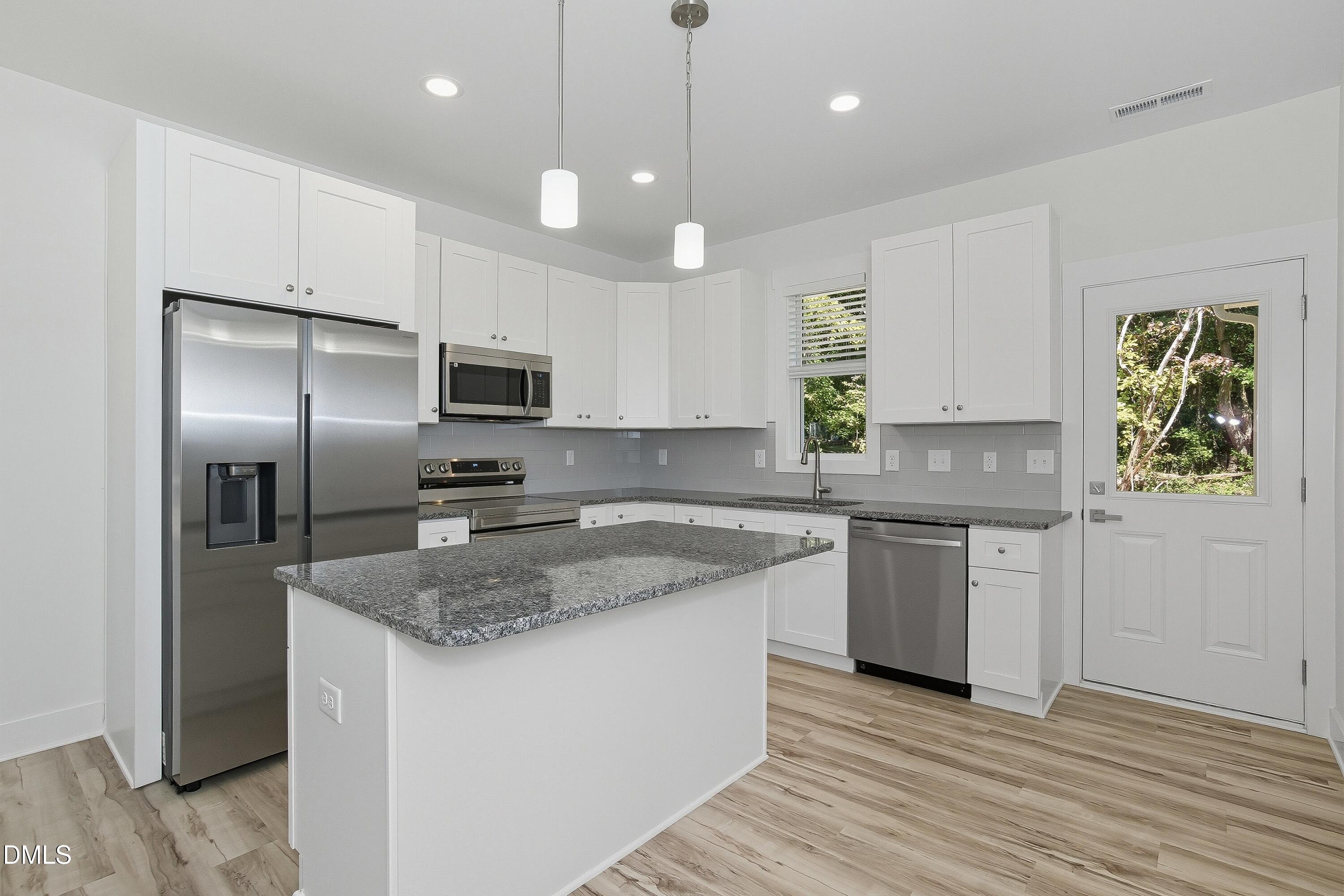 97 Gates Street Roxboro, NC 27573 - Photo 7 of 34 a kitchen with granite countertop stainless steel appliances a stove refrigerator and microwave