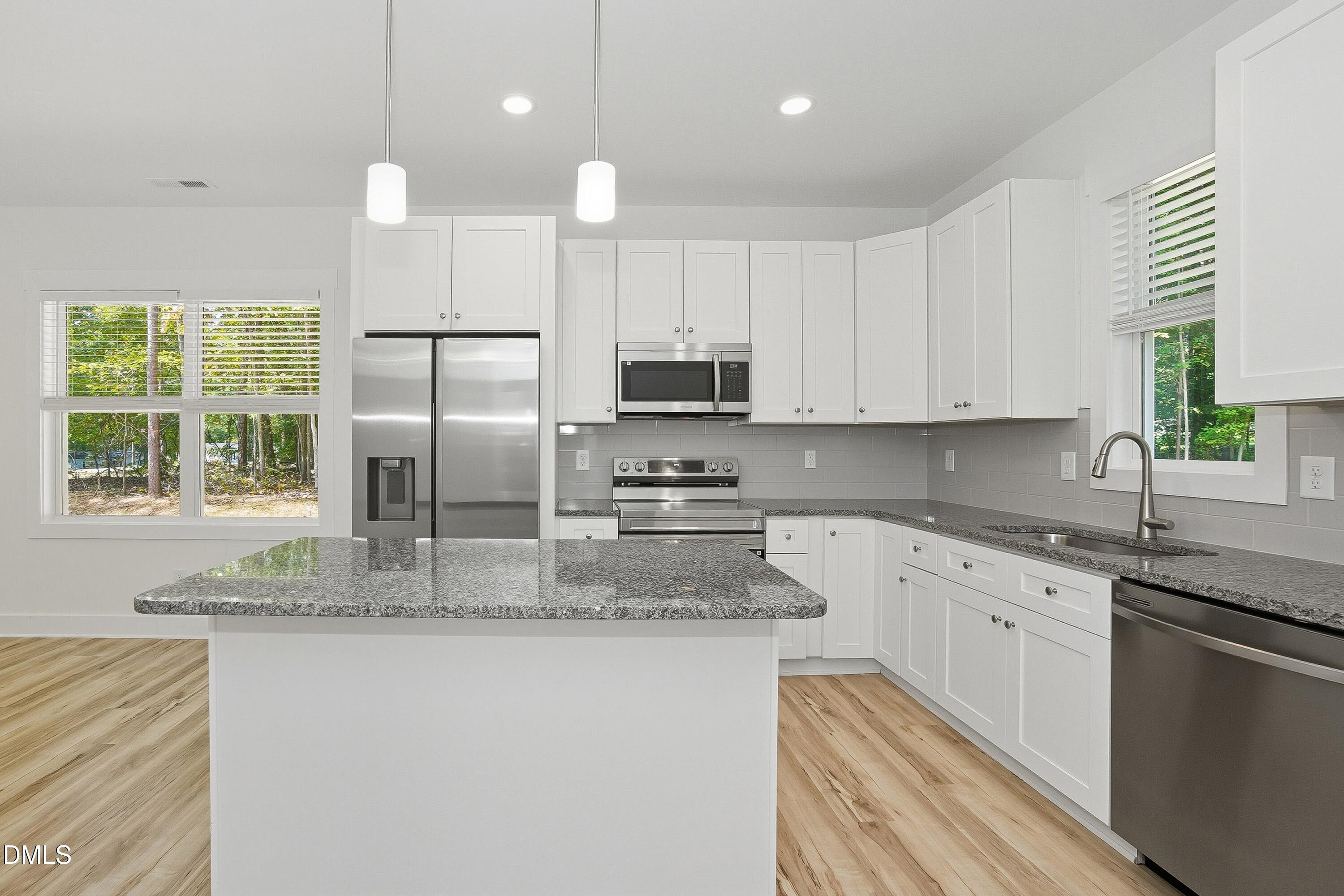 97 Gates Street Roxboro, NC 27573 - Photo 9 of 34 a kitchen with stainless steel appliances granite countertop a sink a stove a refrigerator a center island and cabinets