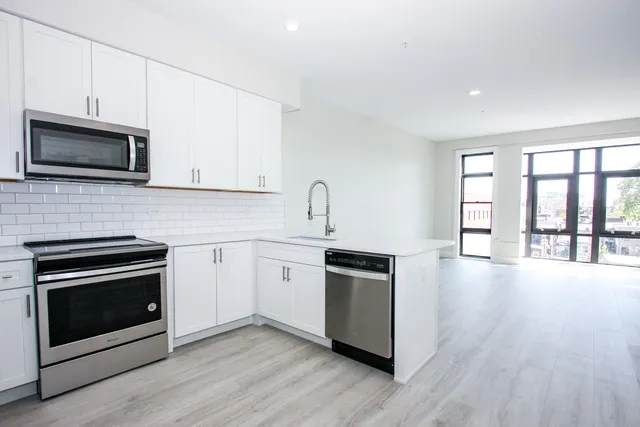 a kitchen with stainless steel appliances granite countertop a stove microwave and sink