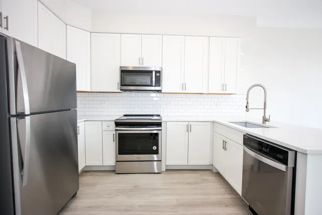 a kitchen with stainless steel appliances a refrigerator stove and microwave