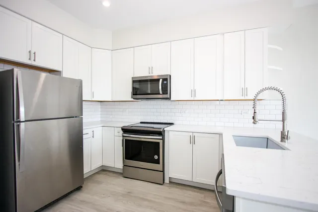 a kitchen with a refrigerator sink and cabinets