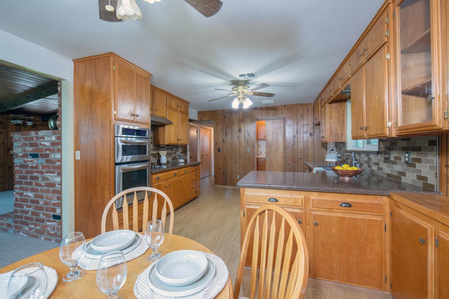 21256 Tollhouse Road Clovis, CA 93619 - Photo 11 of 30 a kitchen with a table chairs sink and cabinets