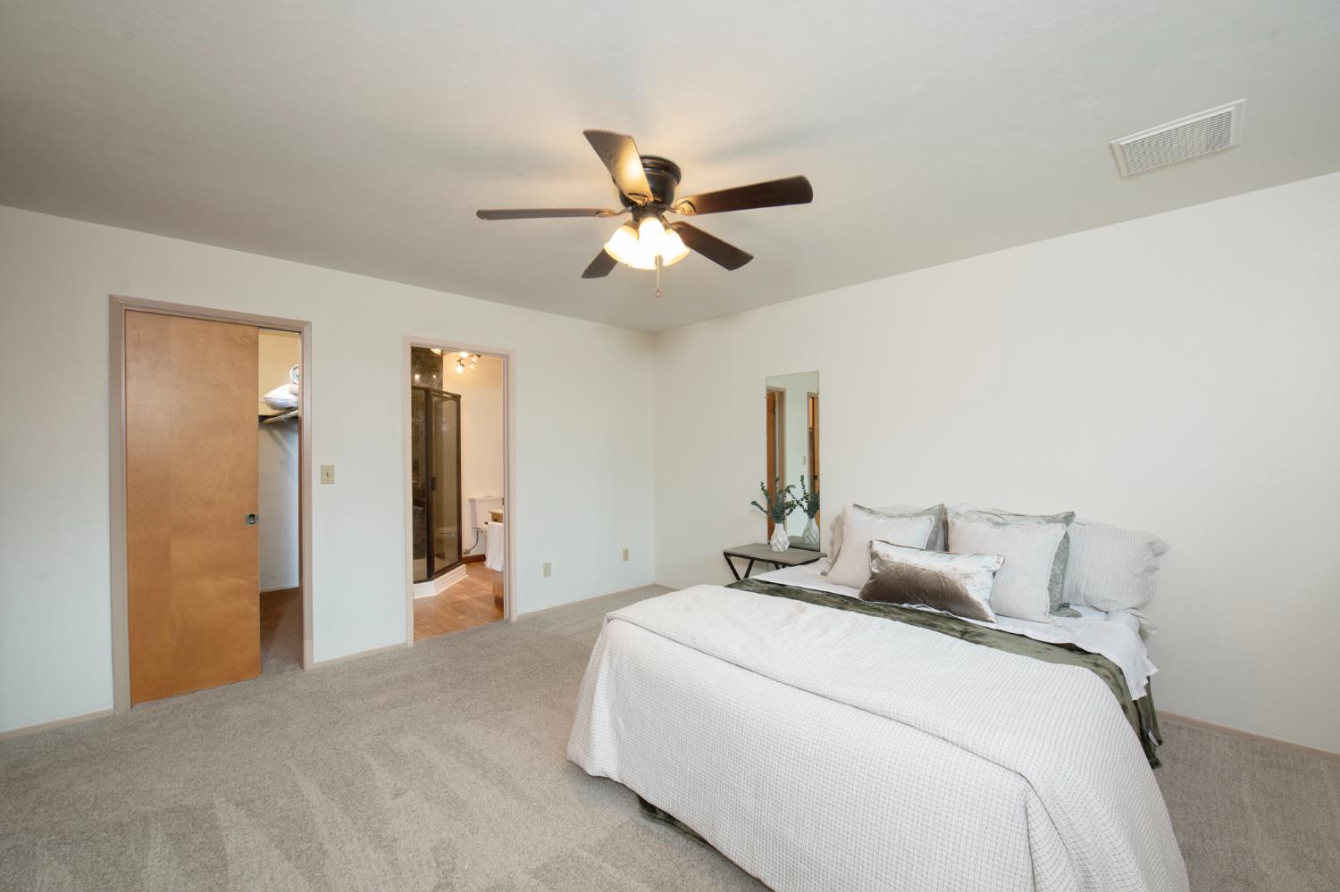 21256 Tollhouse Road Clovis, CA 93619 - Photo 15 of 30 a bedroom with a bed and a chandelier