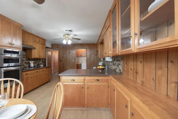 a kitchen with a table chairs sink and cabinets