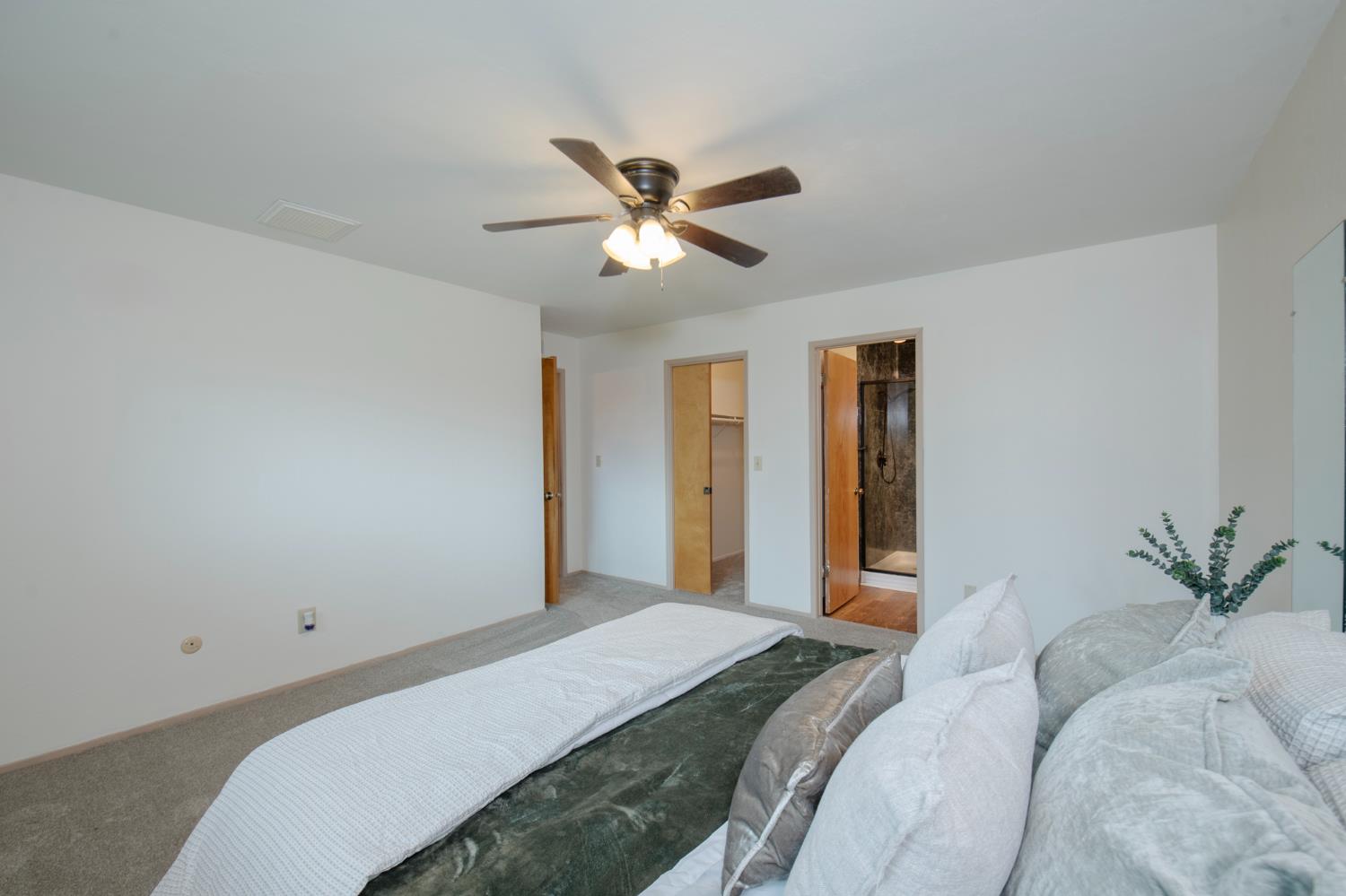 21256 Tollhouse Road Clovis, CA 93619 - Photo 16 of 30 a bedroom with a bed and a chandelier