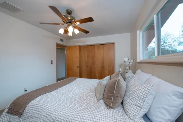 a bedroom with a large bed chandelier and a window