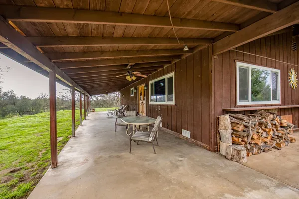a view of a porch with furniture and floor to ceiling window
