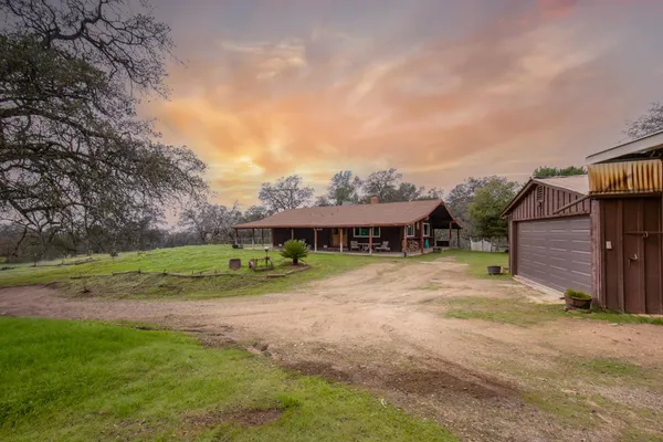 a view of a big house with a big yard and large tree