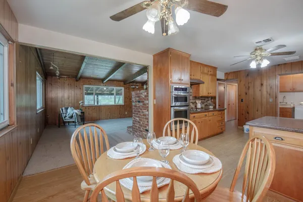 a dining room with furniture a chandelier and window