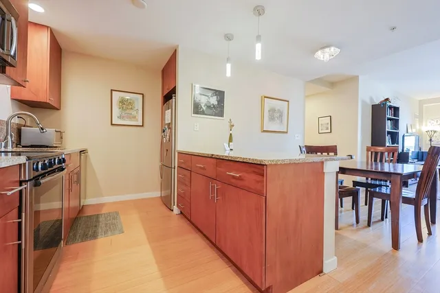a kitchen with stainless steel appliances granite countertop a refrigerator and a stove top oven