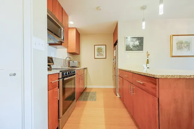 a kitchen with stainless steel appliances granite countertop a stove a sink and a refrigerator