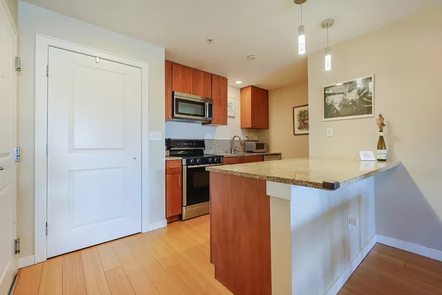 a kitchen with stainless steel appliances granite countertop a refrigerator and a stove top oven