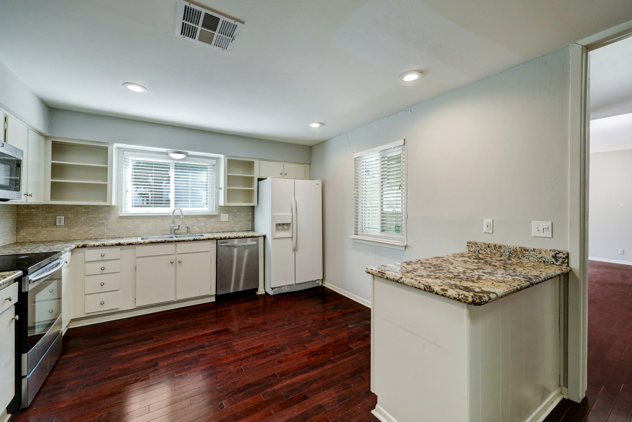 1611 Prairie Mark Lane, Unit 80 Houston, TX 77077 - Photo 4 of 10 a kitchen with granite countertop a sink cabinets and wooden floor