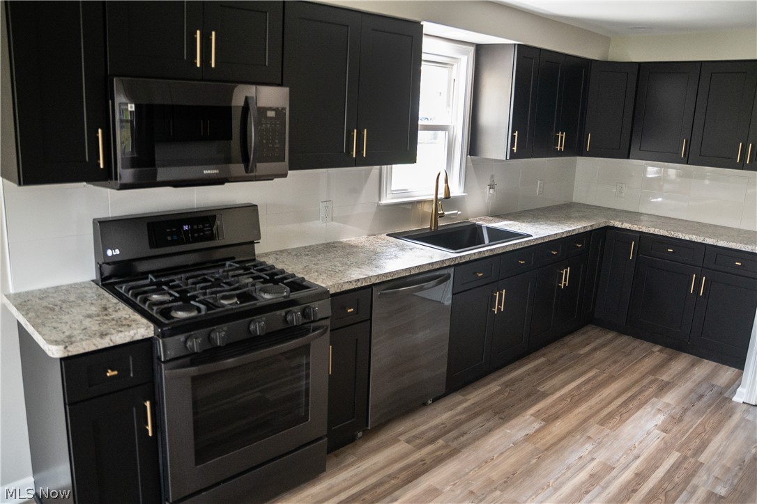 6666 Clingan Road Youngstown, OH 44514 - Photo 16 of 41 Kitchen with view of the new cabinets, backsplash, black stainless appliances and new countertops