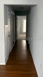 a view of a hallway with wooden floor and stairs