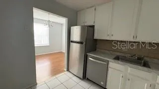 a kitchen with a refrigerator sink and cabinets