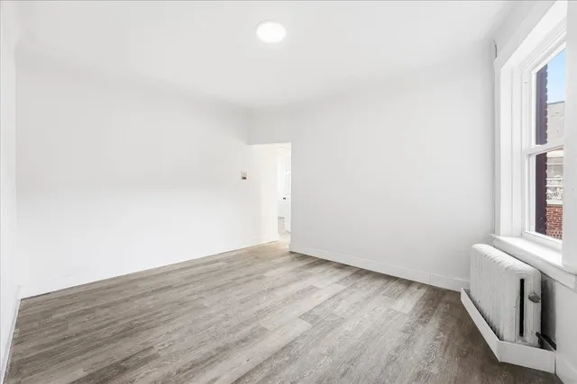 a view of a room with wooden floor and white walls