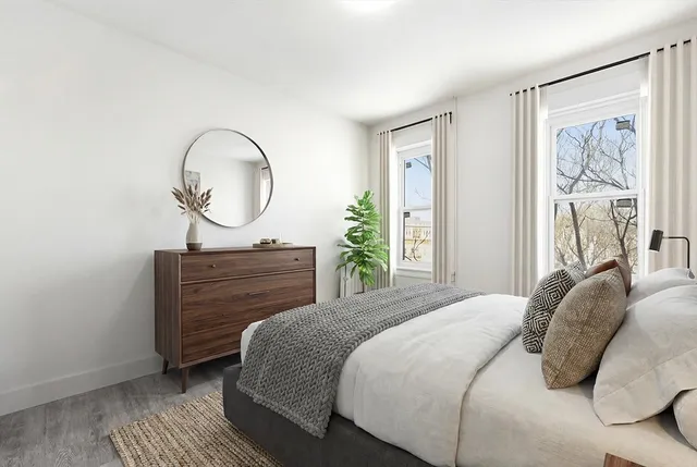 a bedroom with a bed and a large window