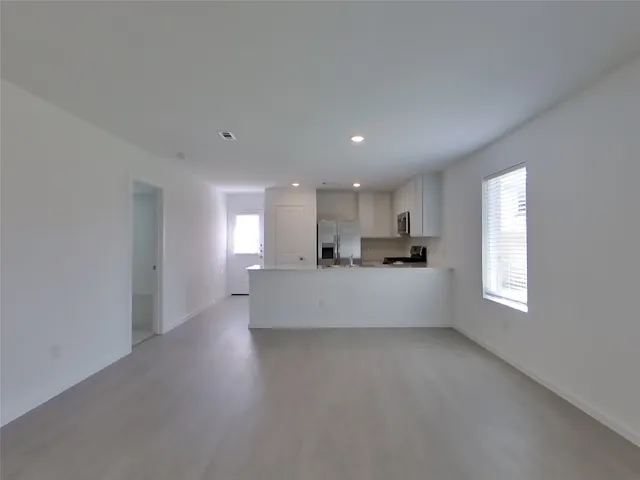 a view of kitchen with kitchen island white cabinets and stainless steel appliances