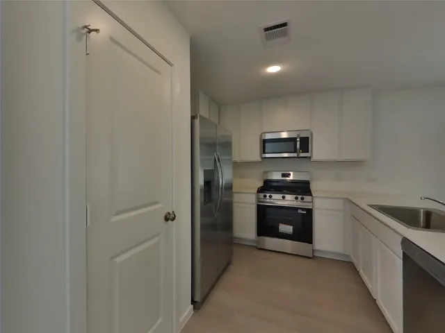 a kitchen with cabinets and stainless steel appliances