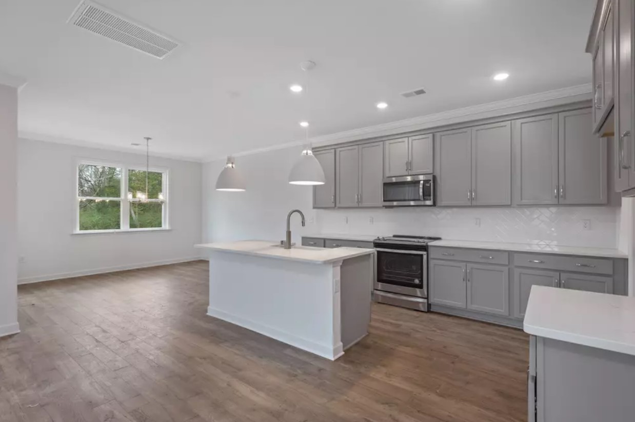 711 Conifer Drive Spring Hill, TN 37174 - Photo 4 of 19 a kitchen with stainless steel appliances granite countertop a stove a sink and a microwave