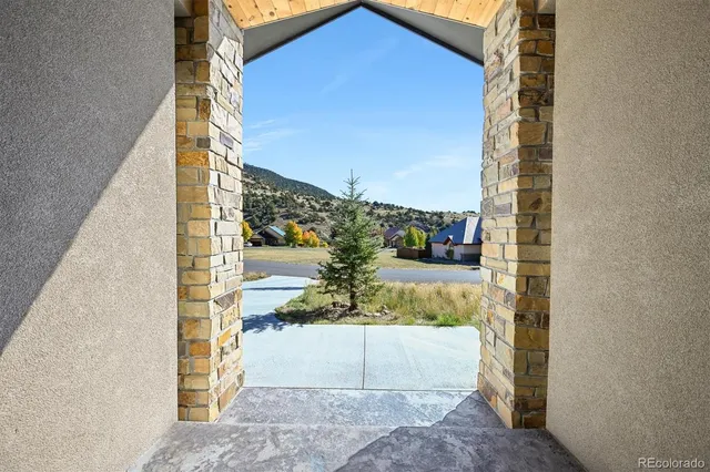a view of a hallway with wooden floor and furniture