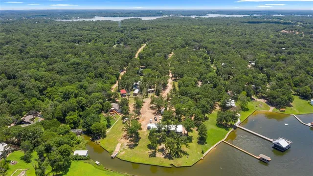 an aerial view of a residential houses with outdoor space and trees