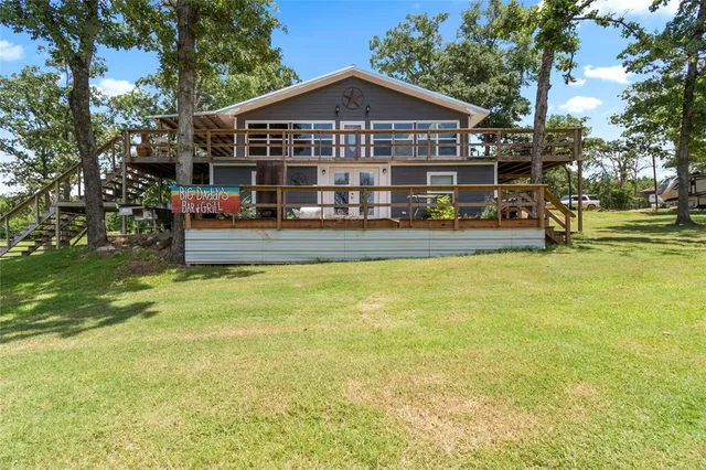 a view of a house next to a big yard with large trees