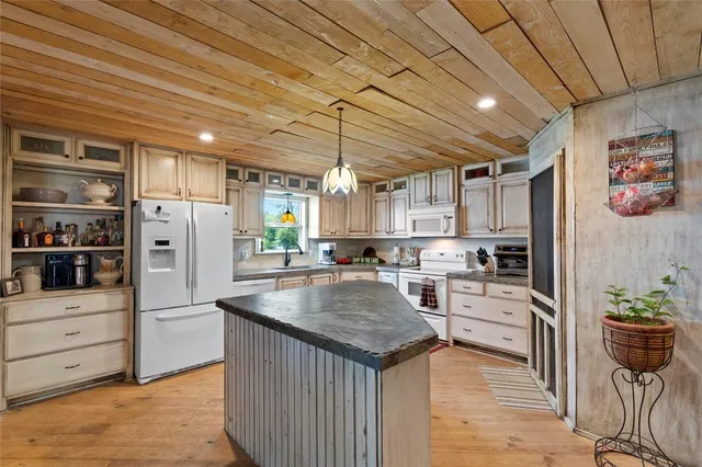 a kitchen with stainless steel appliances granite countertop a refrigerator and a stove top oven