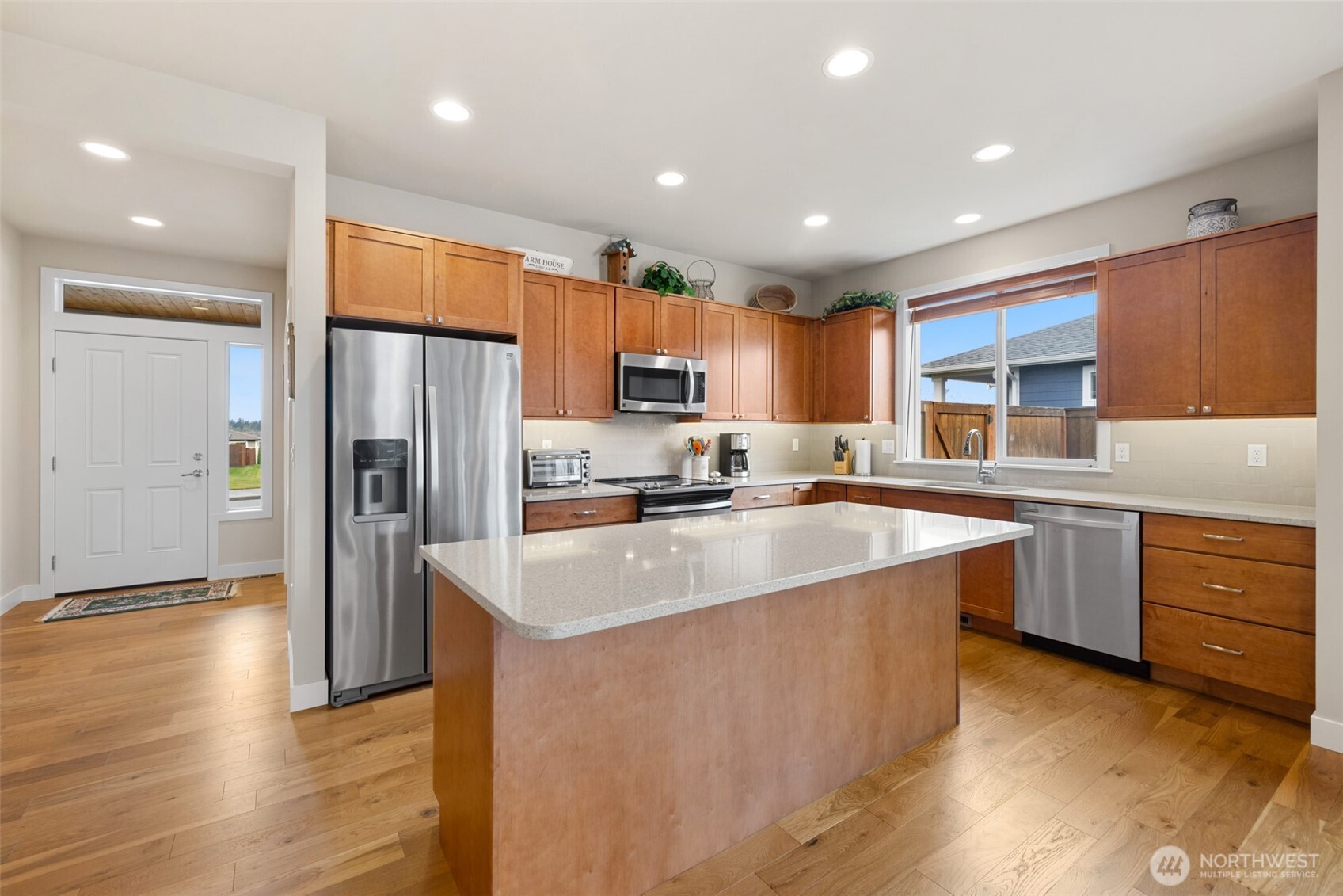 440 Blue Glacier Loop Sequim, WA 98382 - Photo 4 of 34 a kitchen with stainless steel appliances granite countertop a refrigerator a sink dishwasher a stove top oven a refrigerator and cabinets with wooden floor