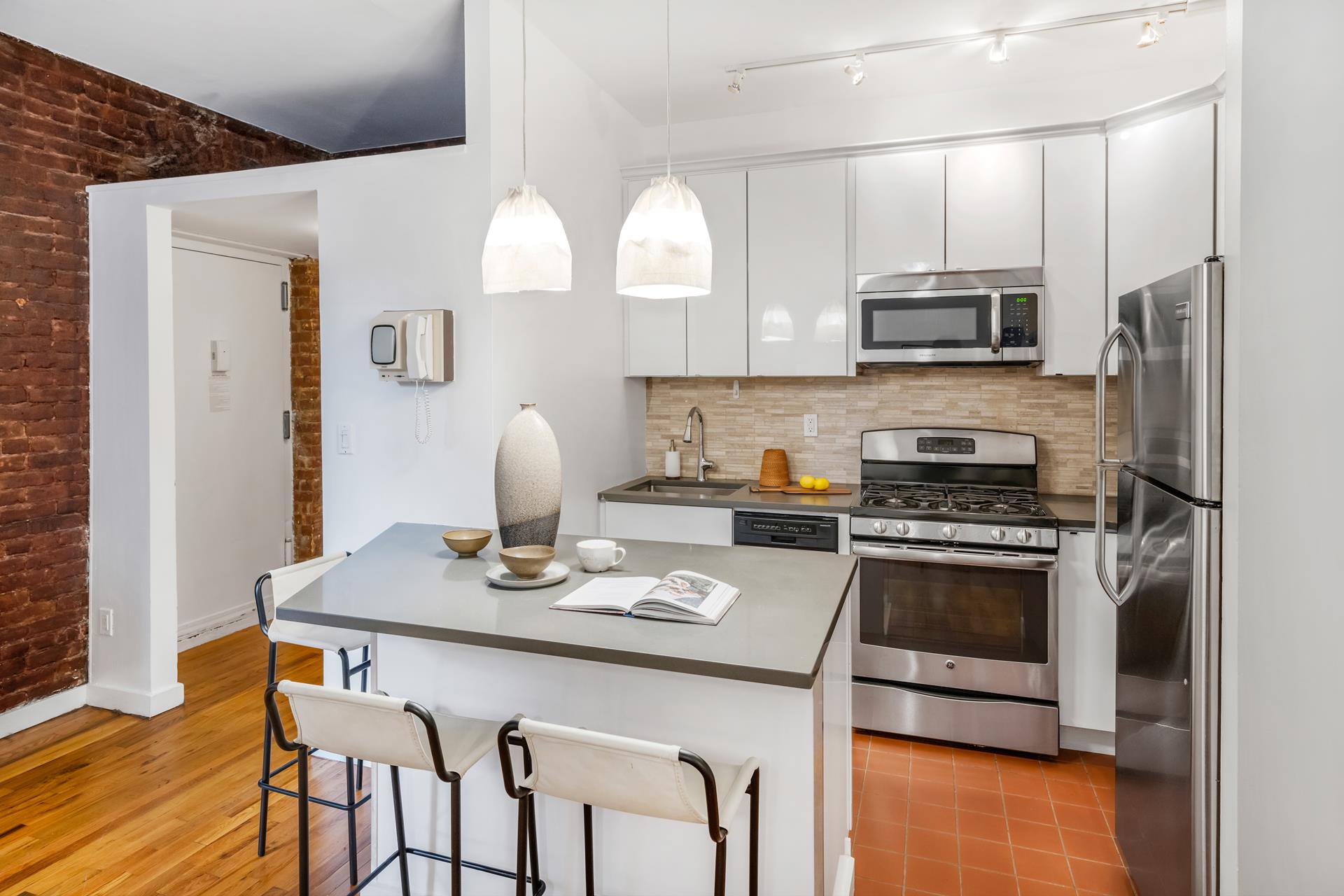 314 West 94th Street, Unit 2A Manhattan, NY 10025 - Photo 4 of 10 a kitchen with stainless steel appliances granite countertop a stove a sink dishwasher a microwave oven and a refrigerator with wooden floor