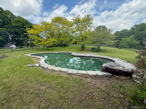 a front view of a house with a yard and potted plants