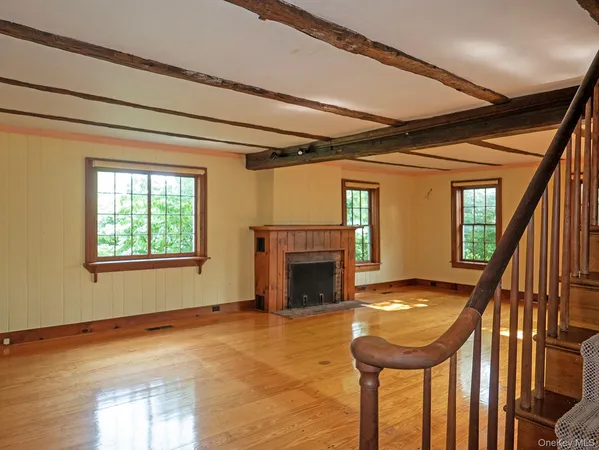 a view of empty room with wooden floor and fireplace