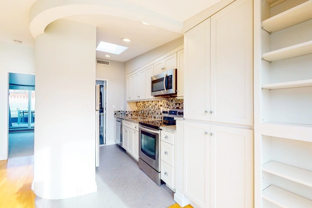 16 Symphony Road, Unit 5 Boston, MA 02115 - Photo 12 of 36 a kitchen with stainless steel appliances granite countertop a refrigerator and a stove