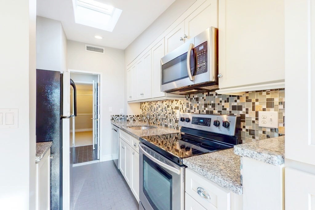 16 Symphony Road, Unit 5 Boston, MA 02115 - Photo 10 of 36 a kitchen with stainless steel appliances granite countertop a stove and a microwave