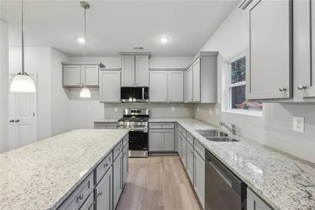 a kitchen with stainless steel appliances granite countertop a sink stove and refrigerator
