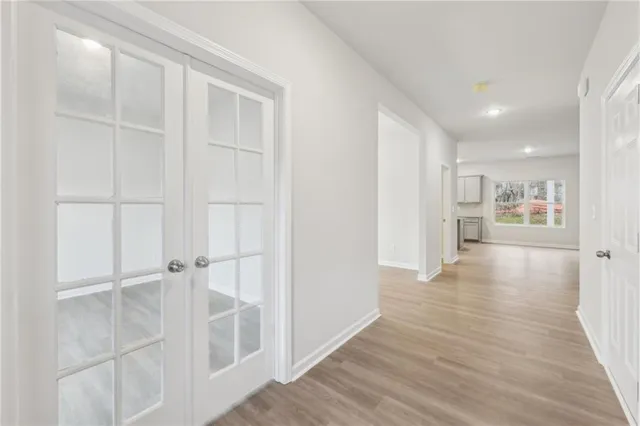 a view of a hallway with wooden floor kitchen and a window