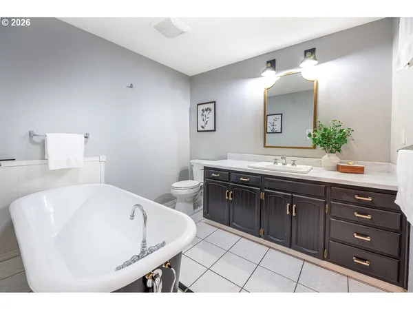 a spacious bathroom with a granite countertop sink and a mirror