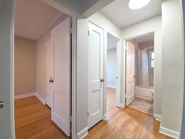 a view of a bathroom with wooden floor and mirror
