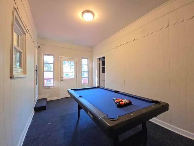 a room with pool table and windows