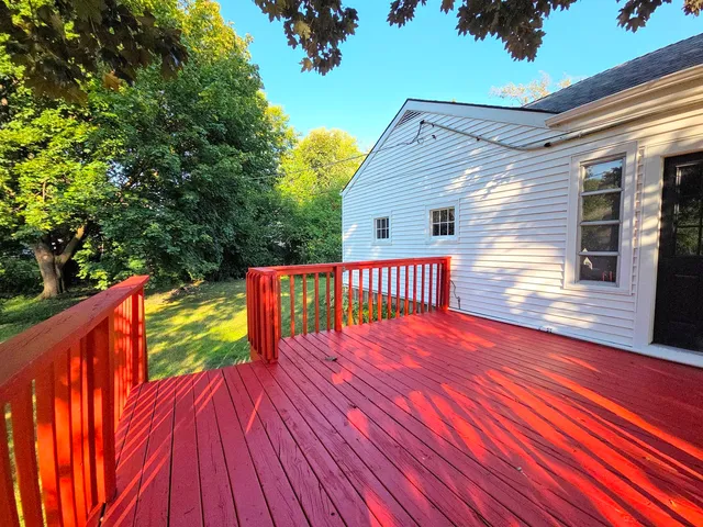 a balcony with wooden floor and outdoor seating