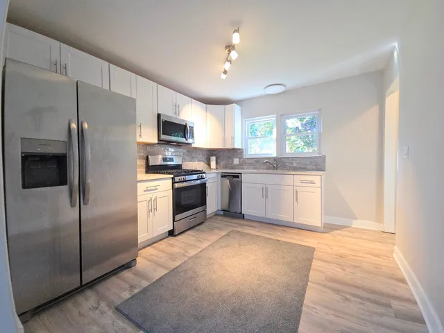 a kitchen with stainless steel appliances granite countertop a stove a sink and a refrigerator