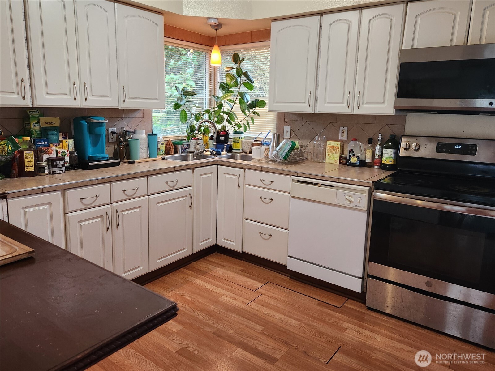 616 South 63rd Street Tacoma, WA 98408 - Photo 6 of 19 a kitchen with stainless steel appliances granite countertop a stove a sink and white cabinets