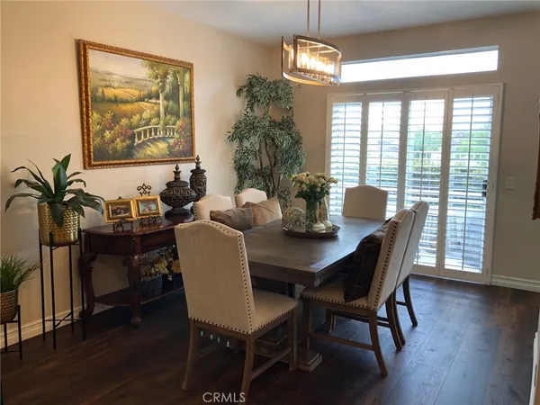 a dining room with furniture a large window and wooden floor