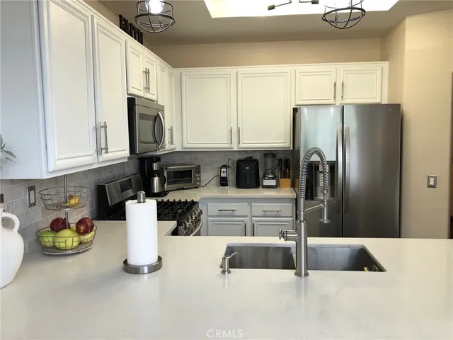 a kitchen with stainless steel appliances granite countertop a refrigerator and a sink