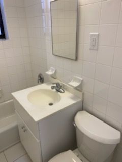 a bathroom with a sink a toilet and mirror